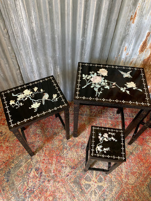 A nest of four black lacquered chinoiserie tables