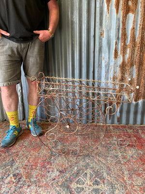 A pair of white wirework barrow plant stands