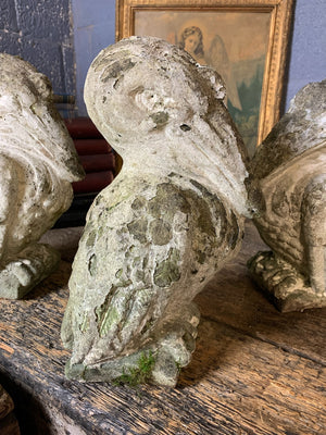 A trio of cast stone pelican statues