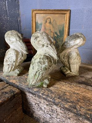 A trio of cast stone pelican statues