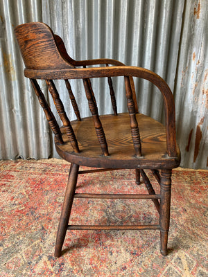 An oak spindle back captain's chair