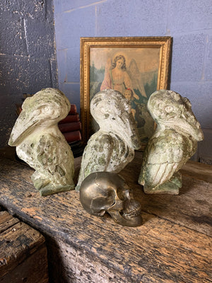 A trio of cast stone pelican statues