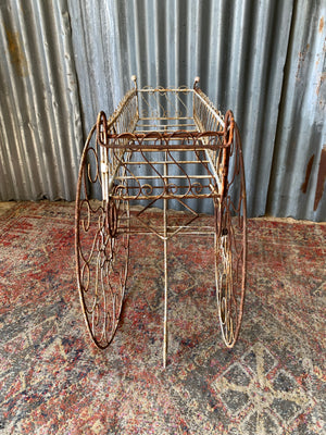A pair of white wirework barrow plant stands