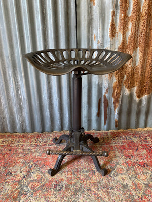 A cast iron adjustable tractor seat stool