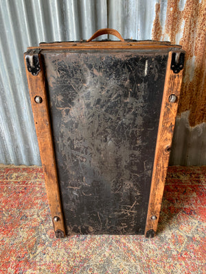 An oak dome top steamer trunk with tooled leather motifs