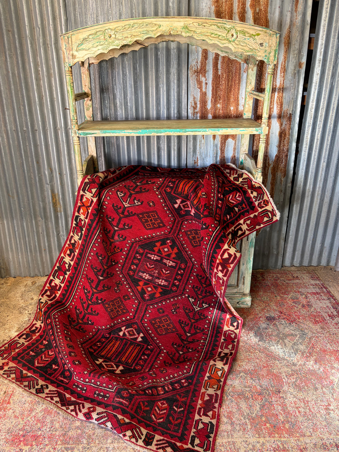 A red ground patterned rug ~ 232cm x 137cm