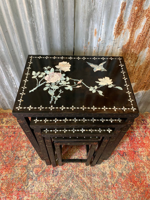 A nest of four black lacquered chinoiserie tables