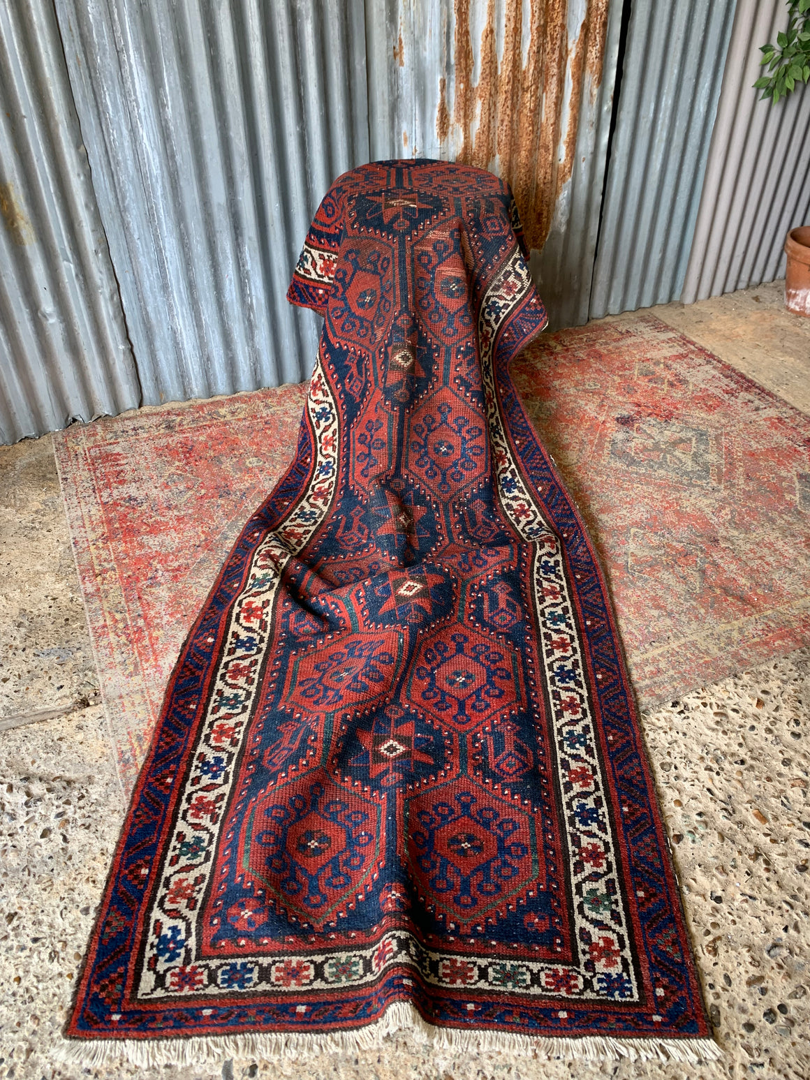 A long red ground blue Persian runner rug ~ 304cm x 104cm