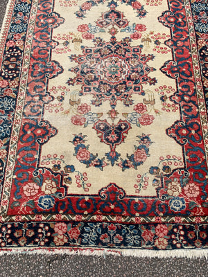 A Persian cream ground rug ~ 194cm x 133cm