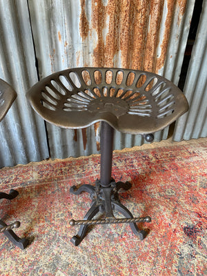 A cast iron adjustable tractor seat stool