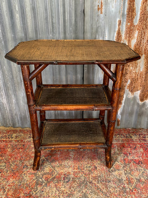 A three tier bamboo occasional table with rattan top