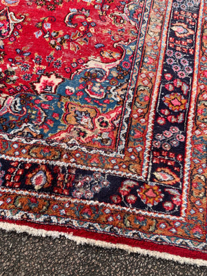 A large red ground Persian rug - 299cm x 194cm