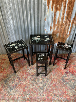 A nest of four black lacquered chinoiserie tables