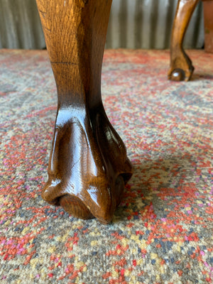 A large red velvet ball and claw footstool