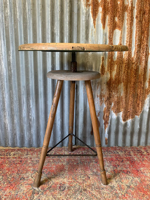 A sculptor's stand with circular oak top