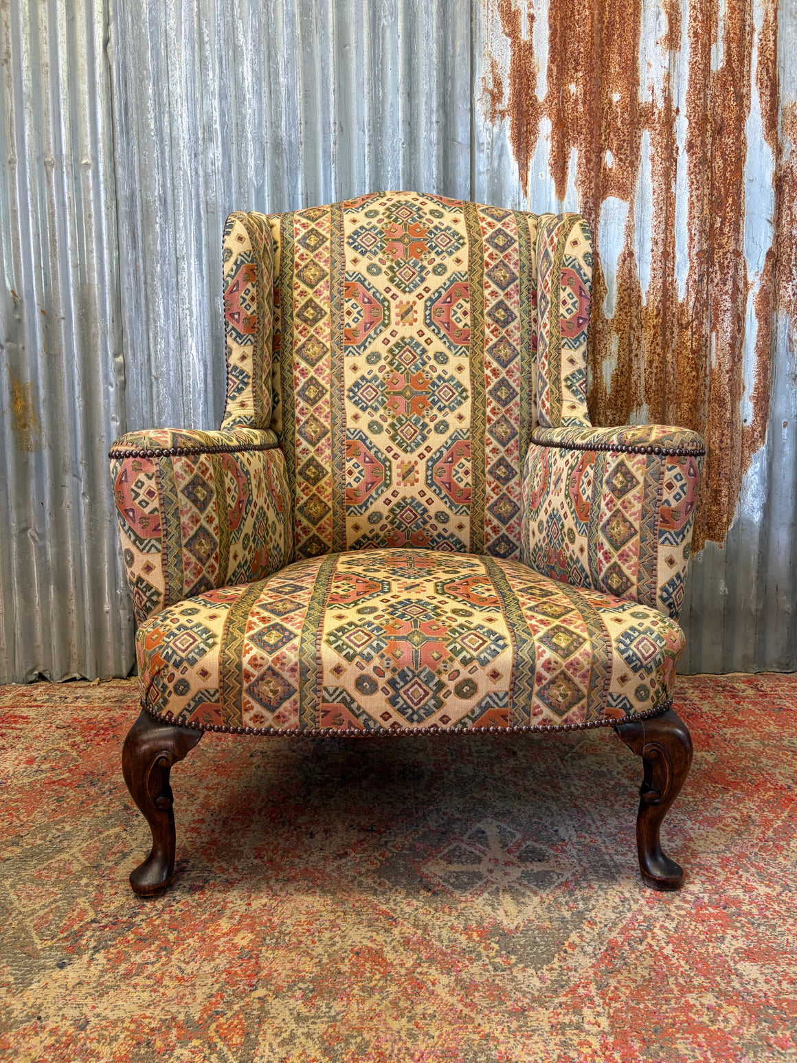A Georgian wingback armchair with tapestry upholstery