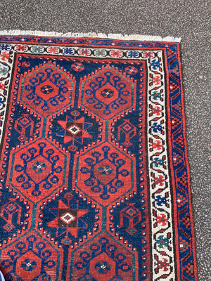 A long red ground blue Persian runner rug ~ 304cm x 104cm