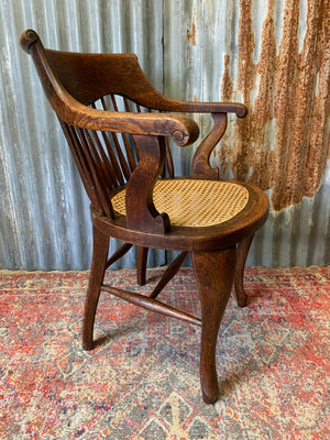 A banker's chair with caned seat