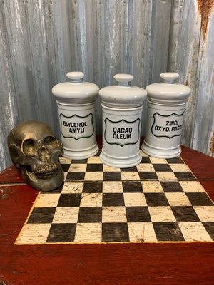 A set of three white ceramic apothecary jars