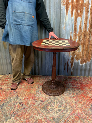 A cast iron bistro table with hand-painted chess board top