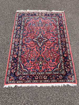 A Persian pink ground wool rug ~ 155cm x 105cm