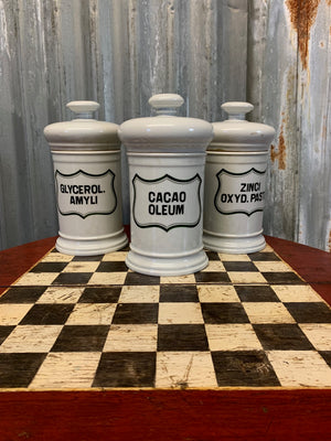 A set of three white ceramic apothecary jars