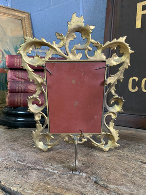 An ornate brass Rococo styled easel back mirror