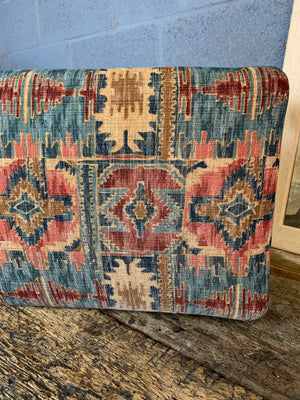 A large kilim-style footstool on cabriole legs