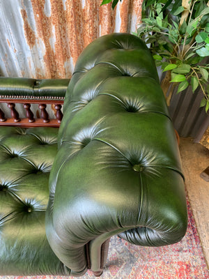 A Victorian-style green leather chaise longue