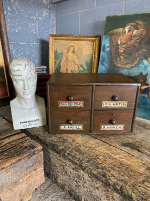 A bank of 4 apothecary drawers with Latin glass labels