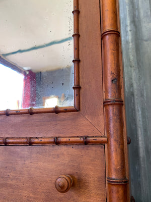 A small French faux bamboo mirrored cabinet