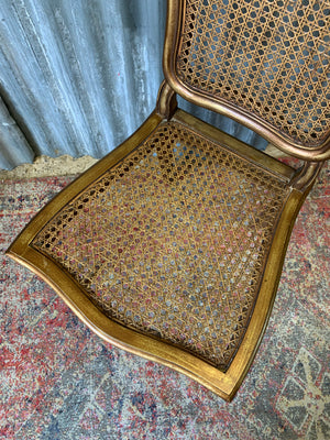 A rococo-style giltwood cane chair