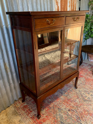 A mahogany double-fronted glass display cabinet with two drawers