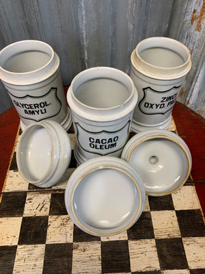 A set of three white ceramic apothecary jars