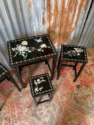 A nest of four black lacquered chinoiserie tables