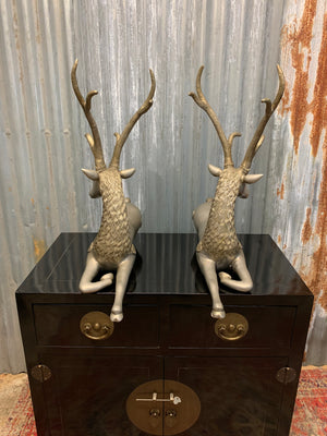 A pair of opposing white metal stags