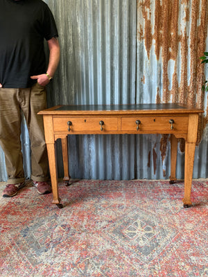 A blonde wood desk on castors