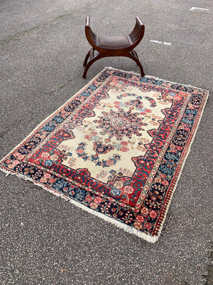 A Persian cream ground rug ~ 194cm x 133cm