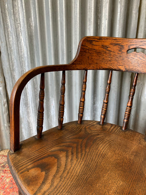 An oak spindle back captain's chair