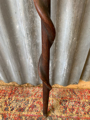 A walking stick with curling snake