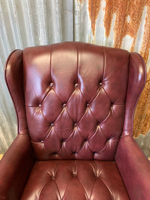 A burgundy leather full button tilt and swivel desk chair
