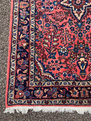 A Persian pink ground wool rug ~ 155cm x 105cm