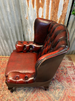 An oxblood wingback Queen Anne-style armchair