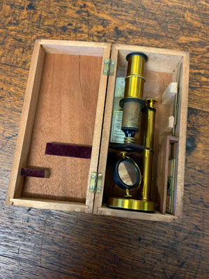 A cased Deyrolle student microscope with slides