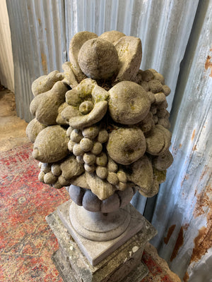 A cast stone cornucopia on plinth