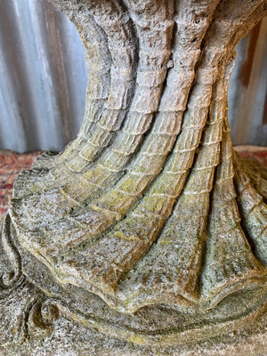 A cast stone bird bath in the form of a shell