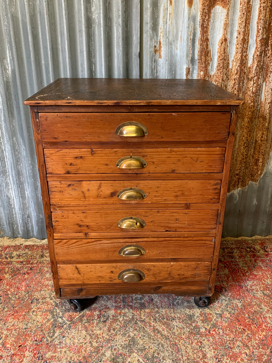 A pine chest of six drawers on castors