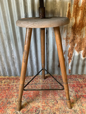 A sculptor's stand with circular oak top