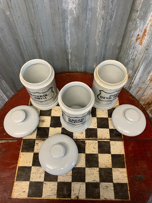 A set of three white ceramic apothecary jars