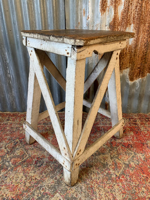 A wooden square-topped sculpture stand